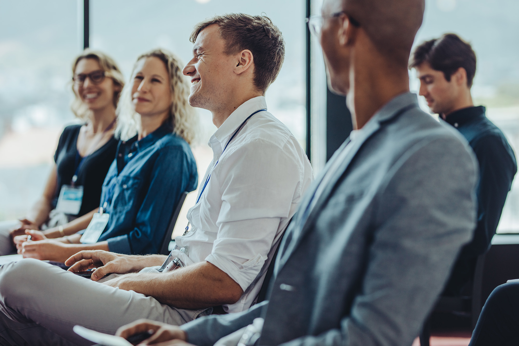 Businessmen and businesswomen sitting in audience. Group of multi-ethnic businesspeople sitting in a seminar.