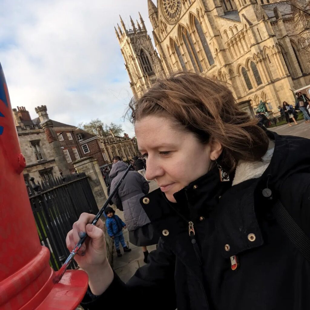 Sian Ellis painting one of the nutcracker statues outside York Minster